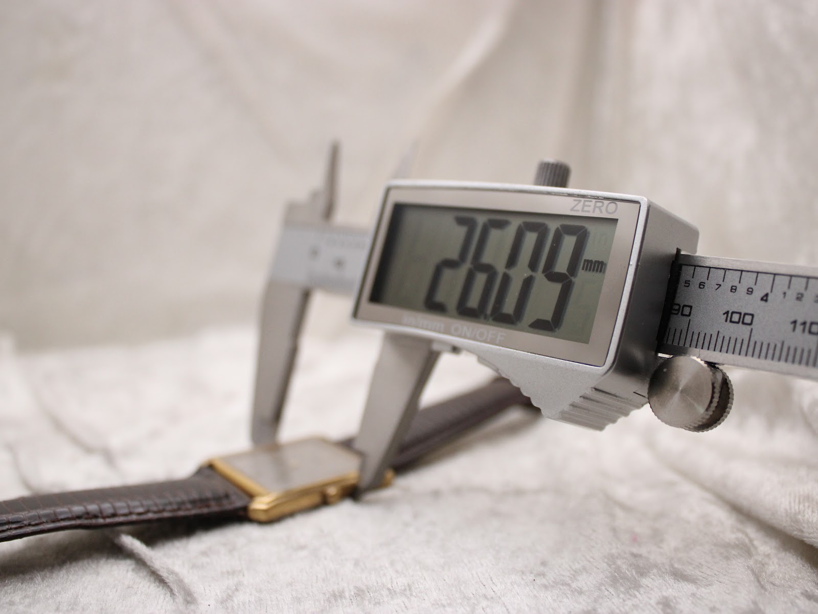 Digital caliper measuring the case width (excluding crown) of the watch, showing a precise reading of 26.09 mm.