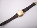Overhead view of the entire Raymond Weil watch from the rear, strap extended, showing the case back and strap underside.