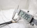 Digital caliper measuring the watch case, displaying a precise diameter of 21.99 mm.