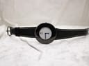 Overhead view of the Raymond Weil Phantôm watch lying flat with its black leather strap extended.