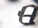 Extreme close-up of the black PVD buckle, showing the engraved 'RW' logo.