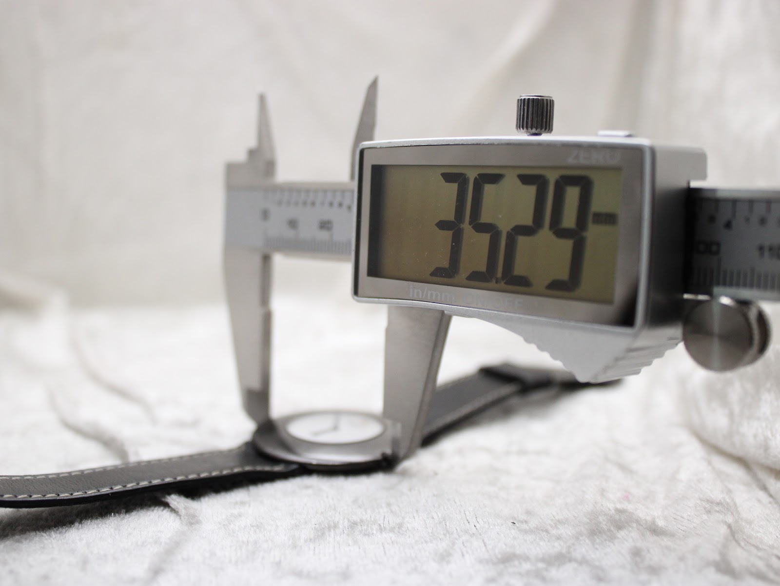 Digital caliper measuring the watch case, showing a precise diameter of 35.29mm.