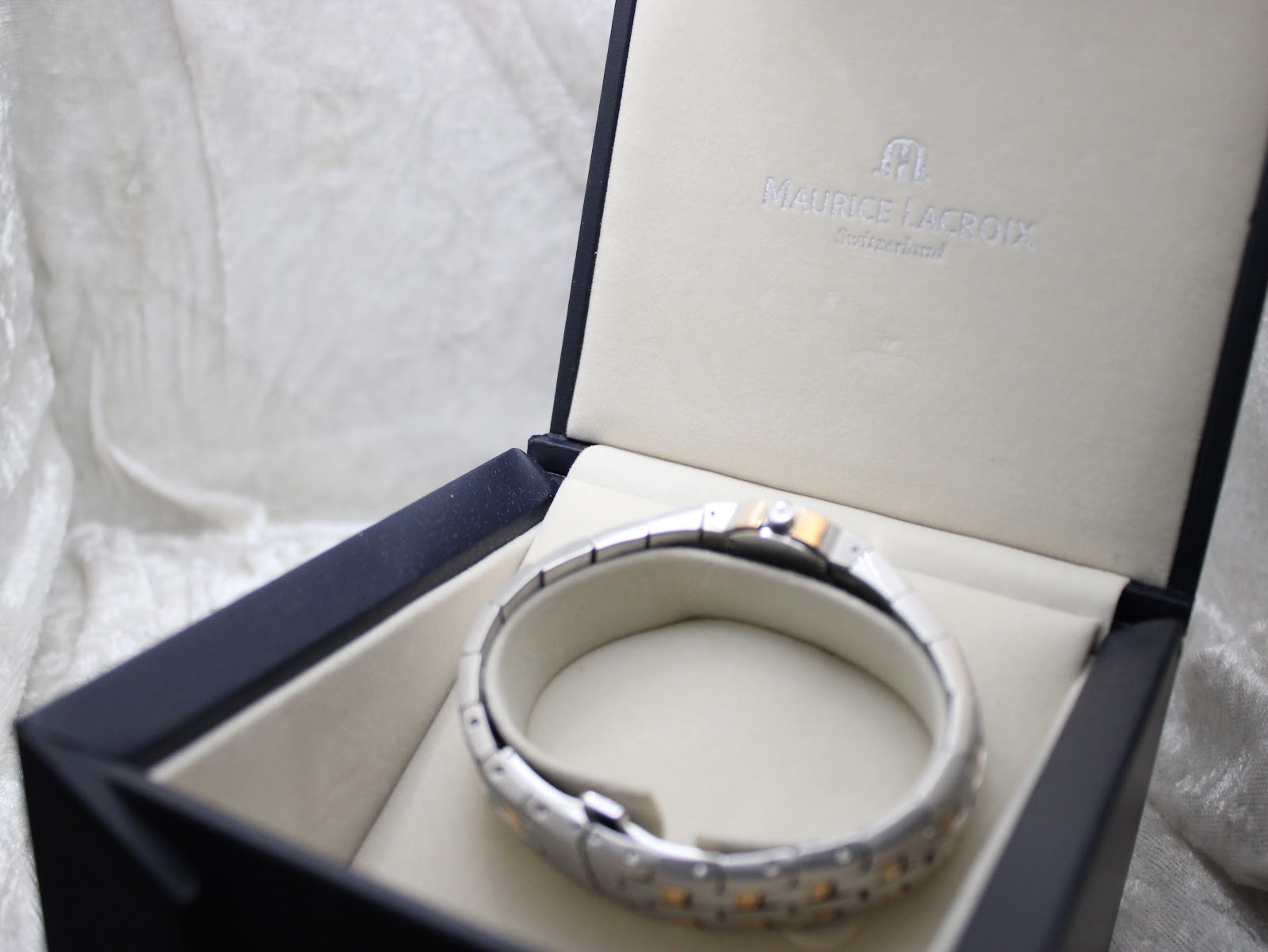 The watch resting inside the plush interior of its original Maurice Lacroix presentation box.