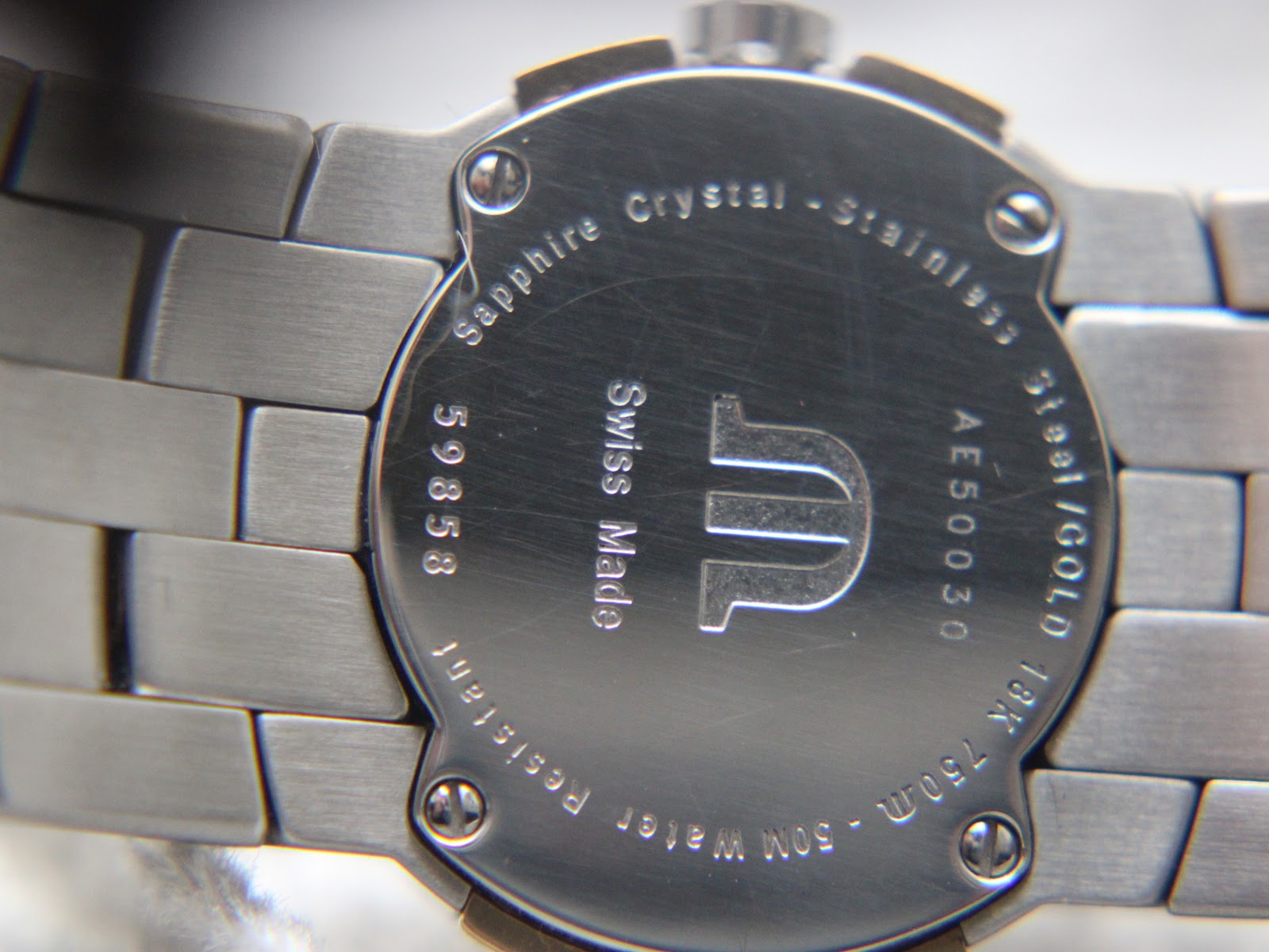 Detailed view of the case back, engraved with model number, serial, materials, and 50M water resistance.