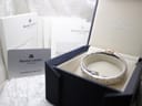 The Maurice Lacroix watch nestled in its original dark blue presentation box, with warranty card and booklets nearby.