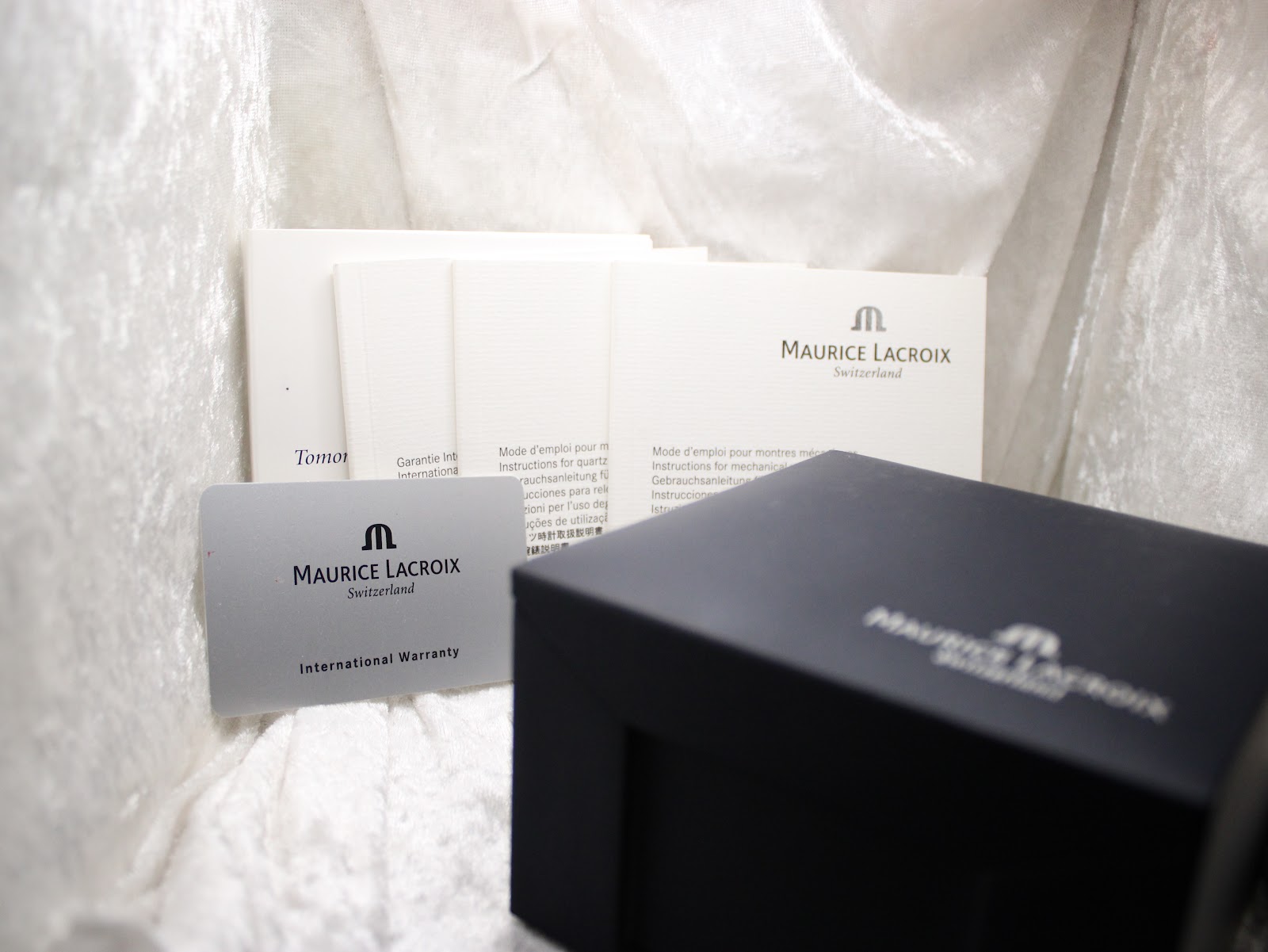 Close-up of the Maurice Lacroix international warranty card and instruction booklets.