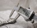 Digital caliper measuring the bezel width of the Tissot PR 200 watch, showing a reading of 24.70mm.