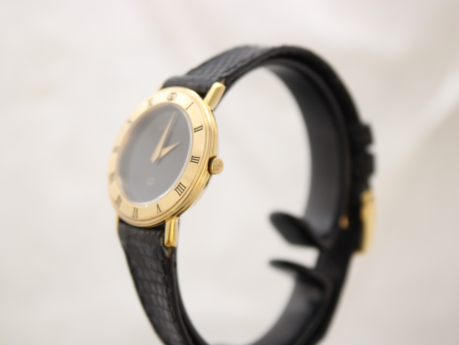 Side profile of Gucci 3000L watch case with signed 'G' crown and slim design.