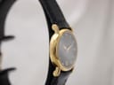 Close-up of black genuine leather strap and gold buckle.