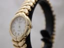 Angled side view of the Raymond Weil Adagio watch on a black stand, showing the fluted crown and curved gold-plated case.