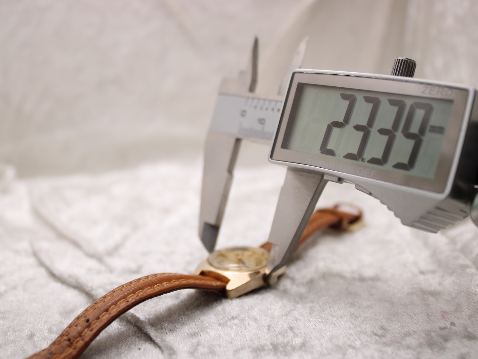 Digital caliper measuring the case diameter of the Bulova watch, displaying 23.39mm.
