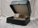 The Raymond Weil Tango watch presented inside an open dark green watch box with a gold crown emblem.