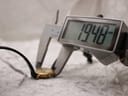 Digital caliper measuring the watch case, displaying a diameter of 19.40 mm, with the watch resting on a light-coloured surface.