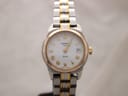 Front view of the Tissot PR 50 ladies' watch, white dial with gold Roman numerals and date, two-tone bracelet.