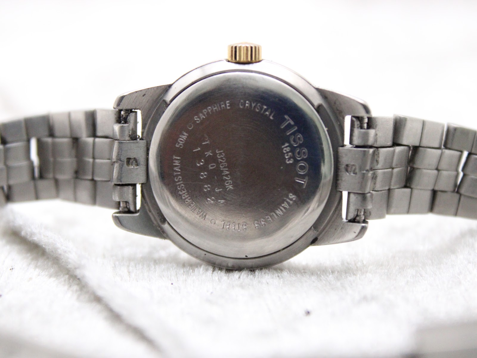 Rear view of the Tissot PR 50 watch case back, showing engravings for 'sapphire crystal', '50M', 'stainless steel' and reference number.