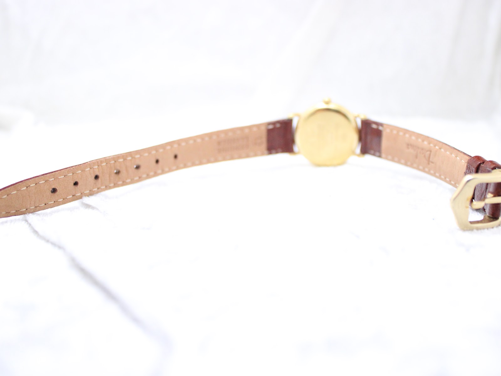 Back view of the Raymond Weil 9923 watch and the brown leather strap, showing the underside of the strap and the gold-tone buckle.