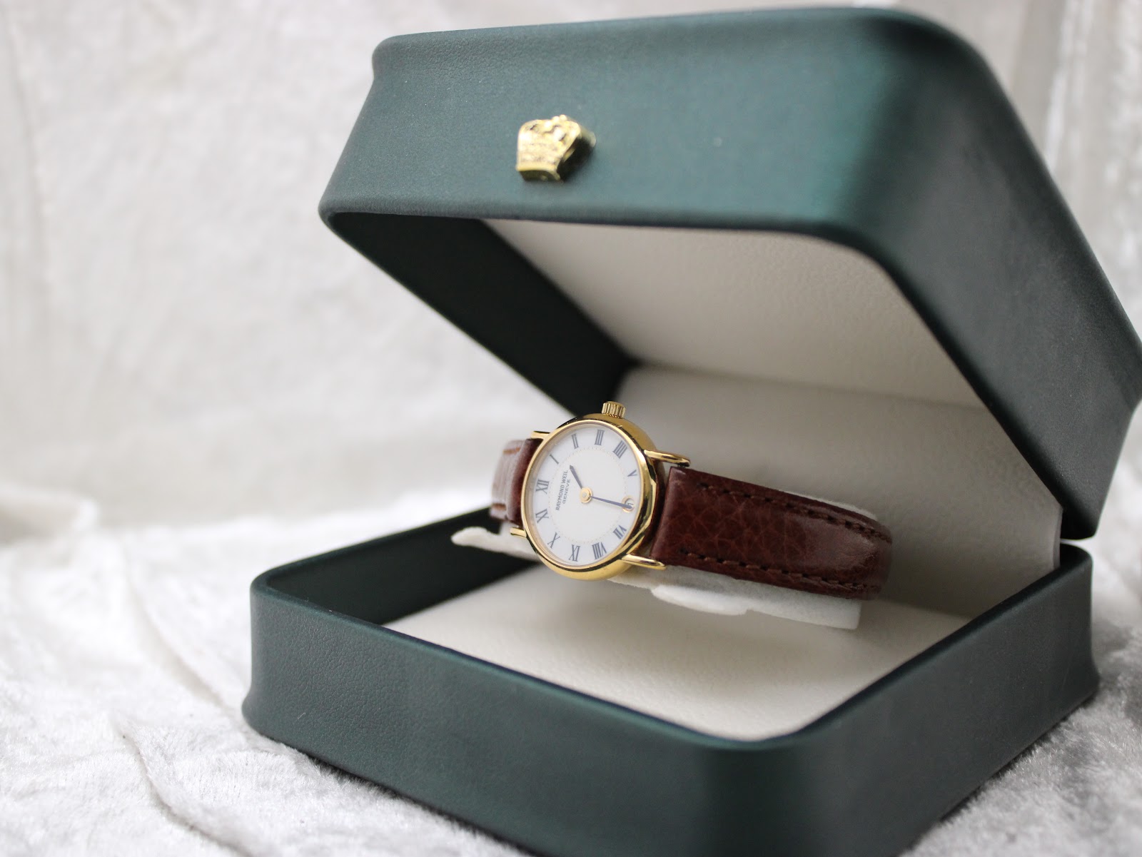 Angled view of the Raymond Weil 9923 watch nestled in a dark green presentation box, showcasing its elegance.