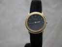 Front view of gold electroplated Raymond Weil 5800 watch with black dial and gold Arabic numerals on a black leather strap.
