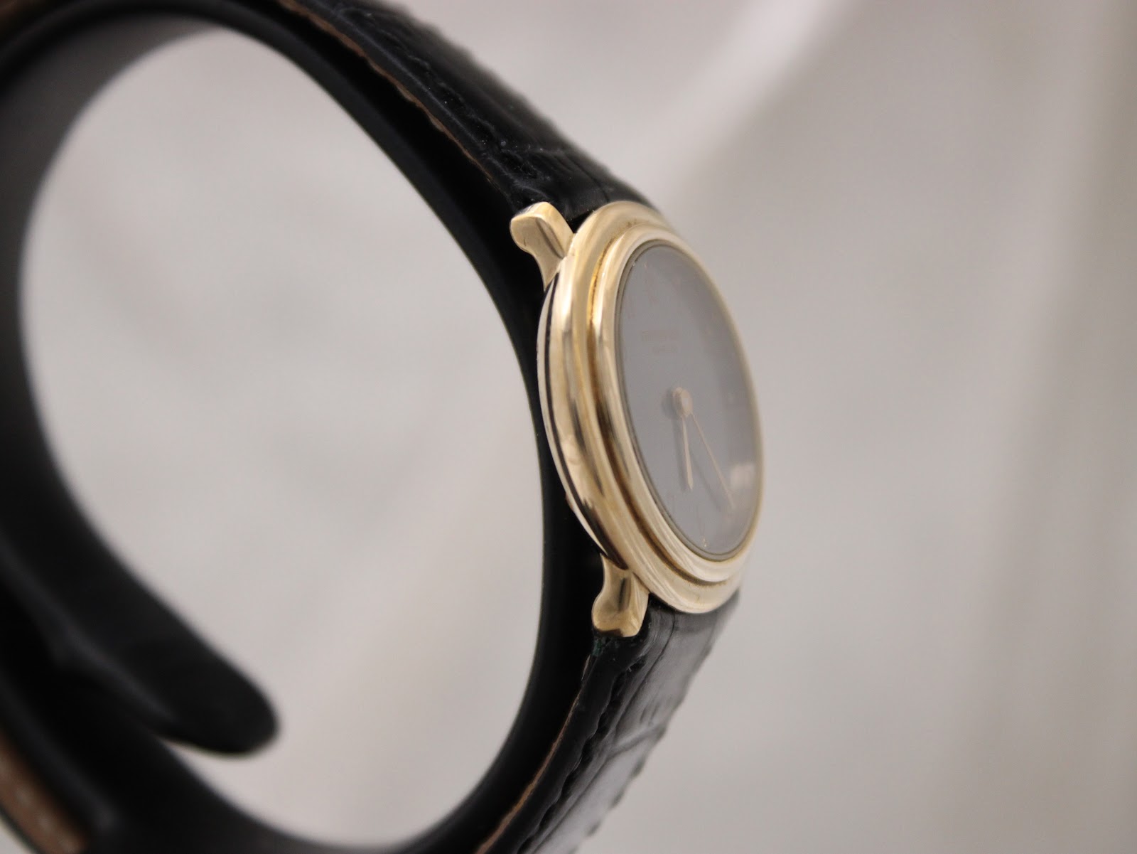 Angled side view of the Raymond Weil 5800, highlighting the elegant gold case and black leather strap.