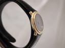 Angled side view of the Raymond Weil 5800, highlighting the elegant gold case and black leather strap.