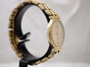 Another side profile view of the gold-tone Raymond Weil watch on a stand, showcasing the integrated bracelet design.