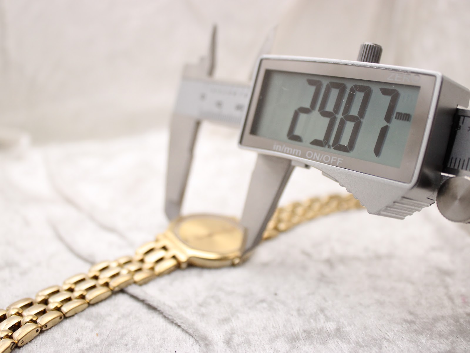Digital caliper measuring the case diameter of the Raymond Weil watch at precisely 29.87mm.