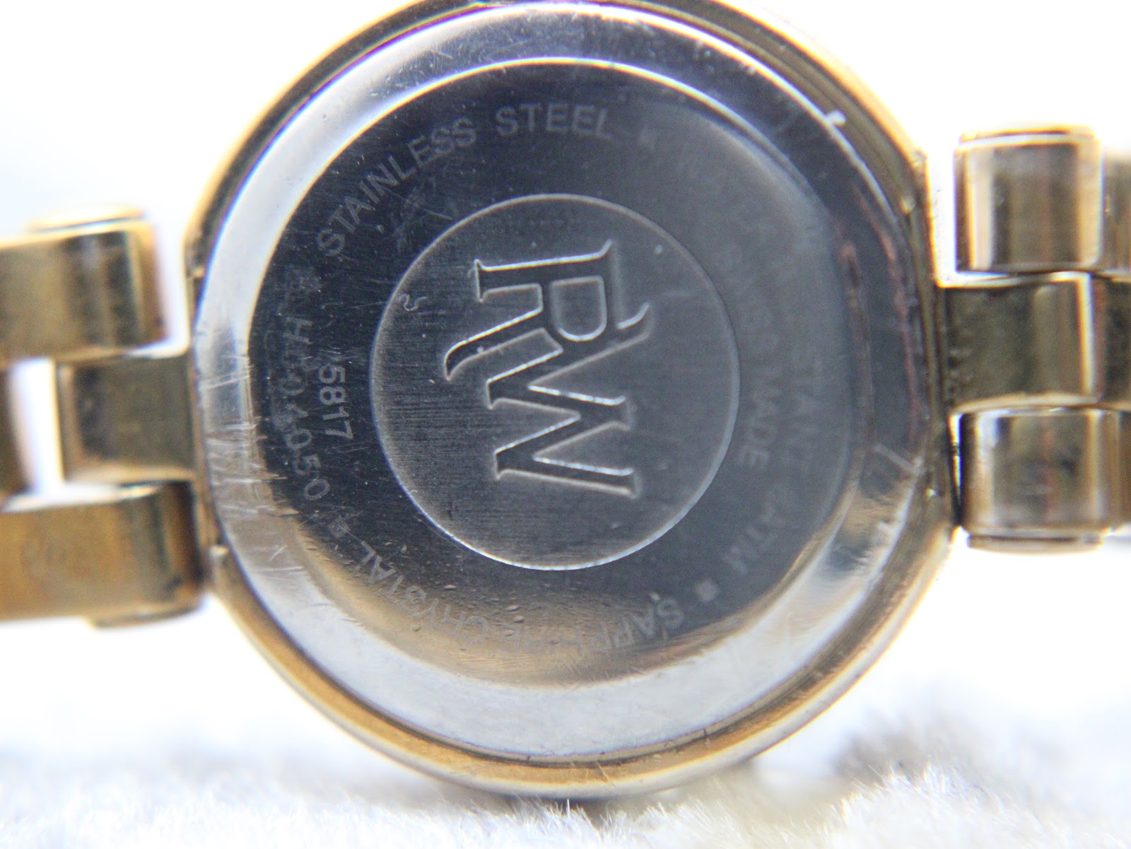 Close-up of the stainless steel case back, showing 'Raymond Weil' and '5817' engravings
