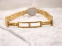 Rear view of the watch bracelet's folded clasp mechanism, showing some gold-tone wear