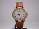 Front view of the Raymond Weil 9155 gold-plated watch with white roman numeral dial and brown leather strap on a stand.