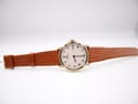 Top-down view of the Raymond Weil 9155 watch with its white roman dial and extended brown leather strap laid flat.