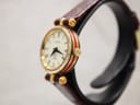 Angled side view showing the gold-plated case with the distinctive green and red Gucci web stripe and crown.