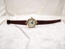 Full front view of the Gucci 2000L watch laid flat on a textured white surface, displaying the burgundy strap.