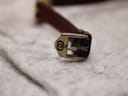 Close-up of the gold-plated buckle with the engraved Gucci interlocking 'G' logo.