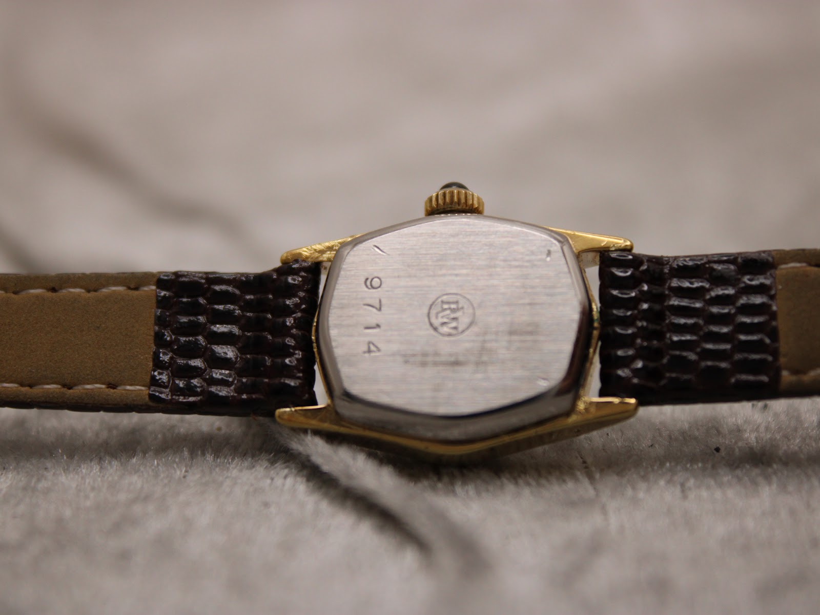 Close-up of the stainless steel case back, showing the engraved "9714" reference number and Raymond Weil logo.