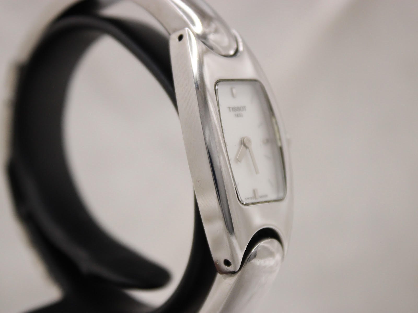 Another side profile view of the Tissot watch, highlighting its elegant, slim design and integrated bracelet.