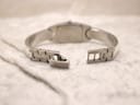 Rear view of the open folding clasp on the stainless steel bangle bracelet of the Tissot watch.