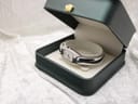 The Tissot C845 ladies' bangle watch displayed in an open, dark green presentation box with a cream interior.