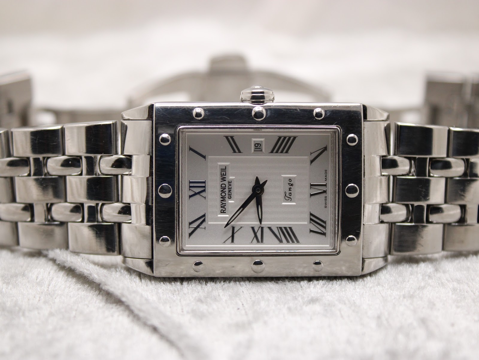 Flat front view of the Raymond Weil Tango watch with its stainless steel bracelet laid open.