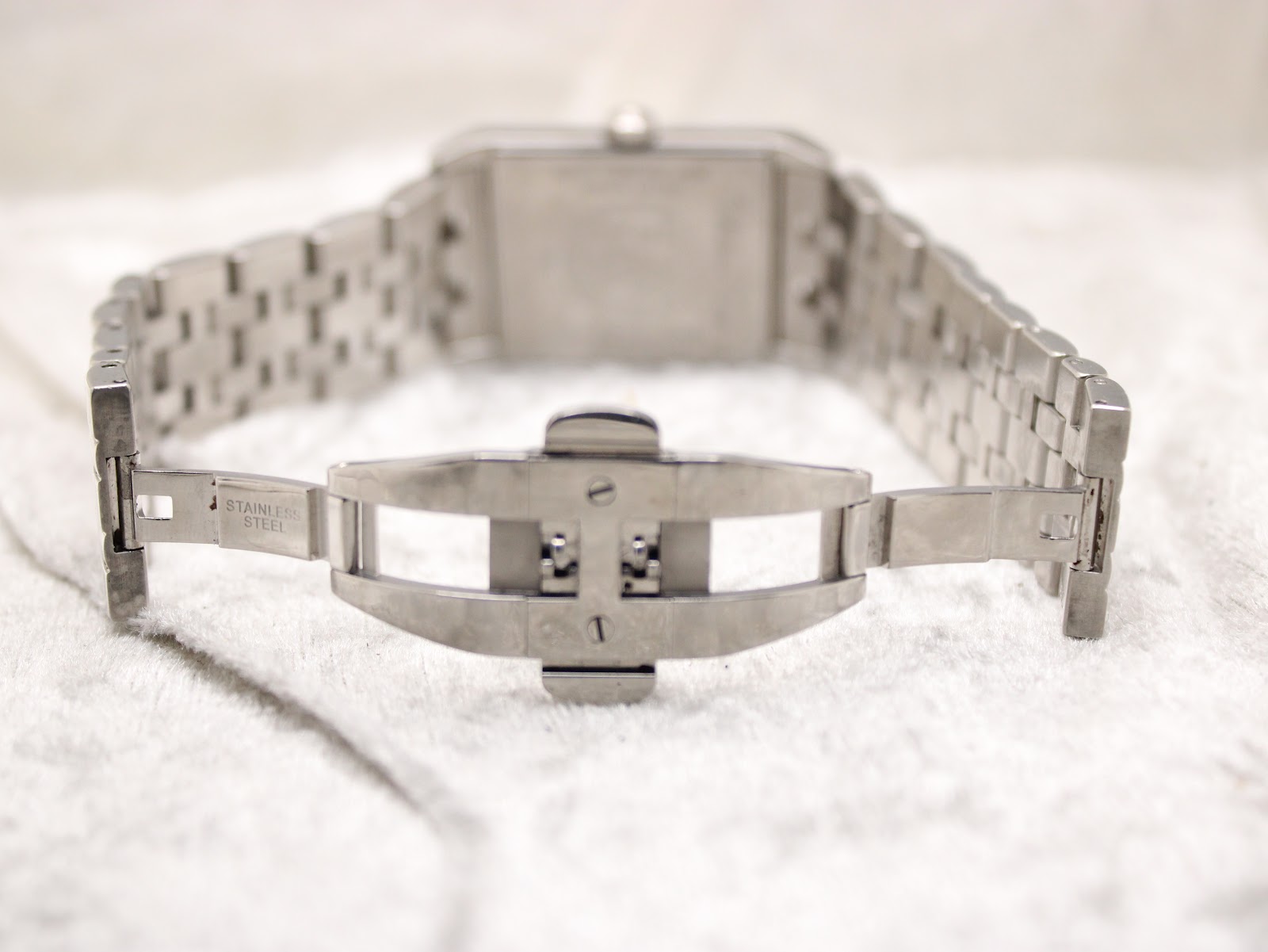 View of the brushed stainless steel folding clasp on the Raymond Weil watch bracelet, with 'Stainless Steel' marking.