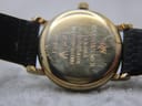 Close-up of the gold-tone case back of the Raymond Weil watch, showing engravings including 'RAYMOND WEIL GENEVE', '18K GOLD ELECTROPLATED', and '9923'.