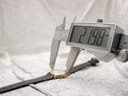 Digital caliper measuring the case diameter of the Raymond Weil watch, displaying a precise measurement of 21.98mm.