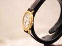Side profile of the gold electroplated Raymond Weil watch on a display stand, highlighting its slim case.