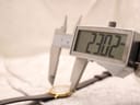 Close-up of a digital caliper measuring the watch case diameter, displaying 23.02mm.