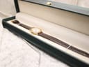 The Raymond Weil watch neatly placed inside a dark green presentation box with an off-white interior.