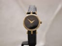 Front view of the Gucci 2000L watch, showing black dial with gold hands and gold-plated case on a black leather strap.