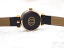 Top-down view of the Gucci 2000L case back, featuring the gold interlocking G logo on a black background.