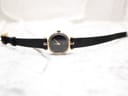 Full length view of the Gucci 2000L watch with its black lizard calf strap on a light background.