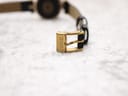 Close-up of the gold-tone pin buckle of the Gucci 2000L, clearly signed with the 'GUCCI' logo.