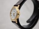 Right side view of the Raymond Weil 5331 watch, showing the gold-plated case and crown on a stand.