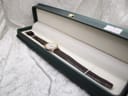 Angled view of the Raymond Weil 5331 watch lying inside a dark green presentation box.